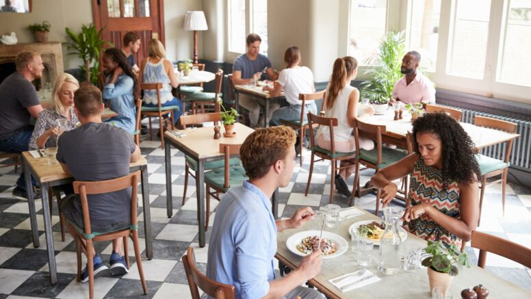 Zufriedene Gäste essen in einem Restaurant nach einer erfolgreichen Reservierung