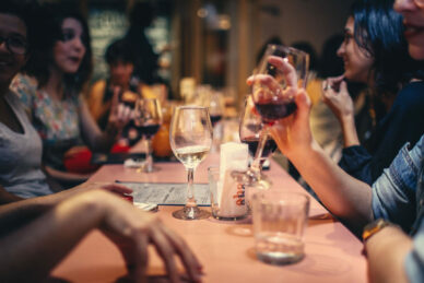 Die Nahaufnahme einer am Tisch sitzenden und Wein trinkenden Gruppe 