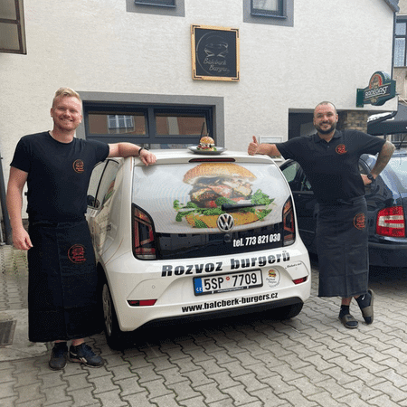 Deux restaurateurs à côté de leur voiture de livraison