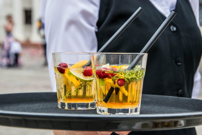 Un serveur porte deux cocktails sur un plateau