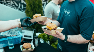 Burger werden auf einem Streetfoodmarkt überreicht