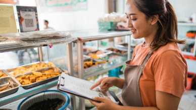 Gastronomin mit einer Checkliste im Restaurant